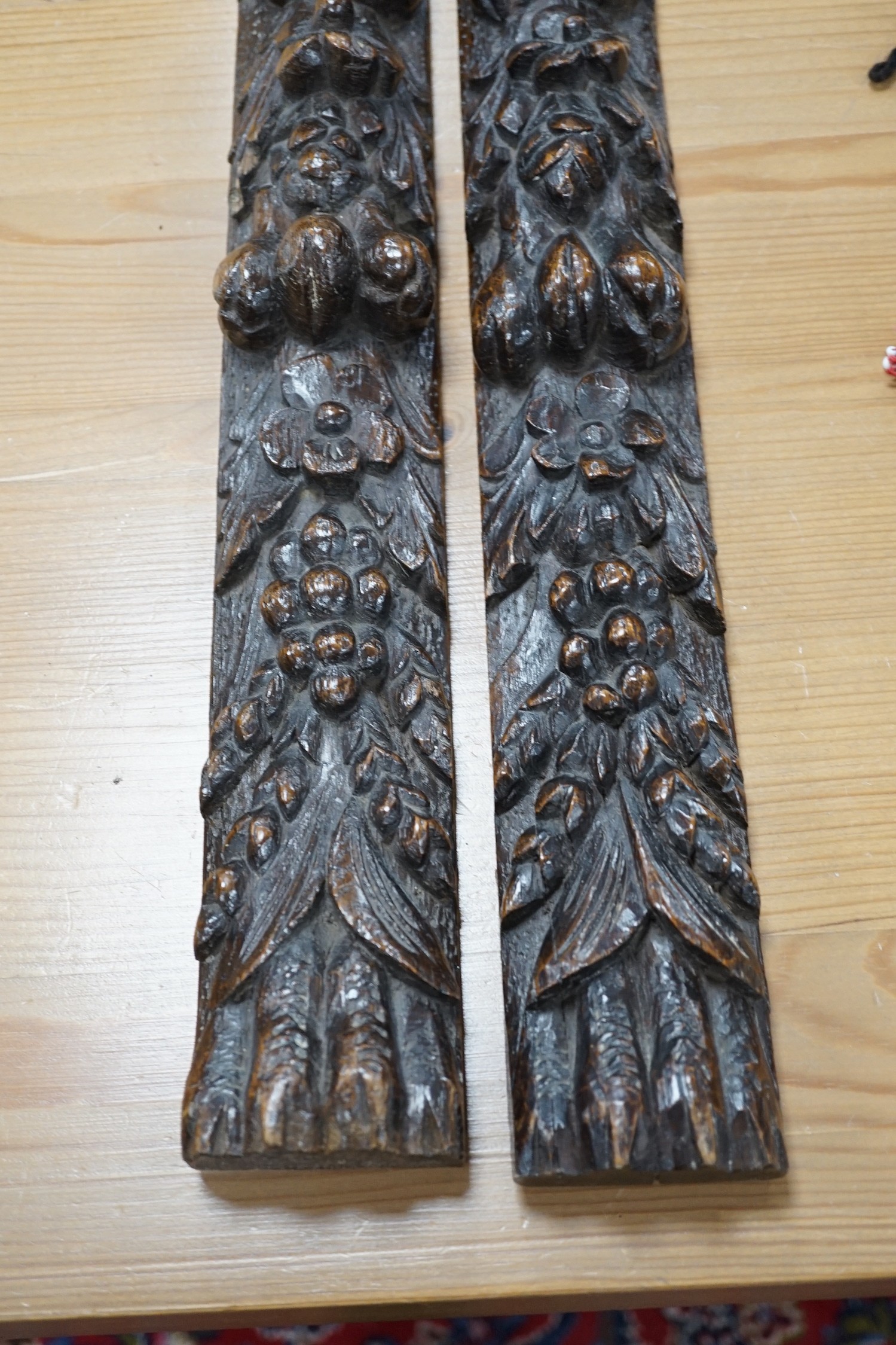 A pair of early carved wood hanging mouldings in the Flemish style, 81cm tall